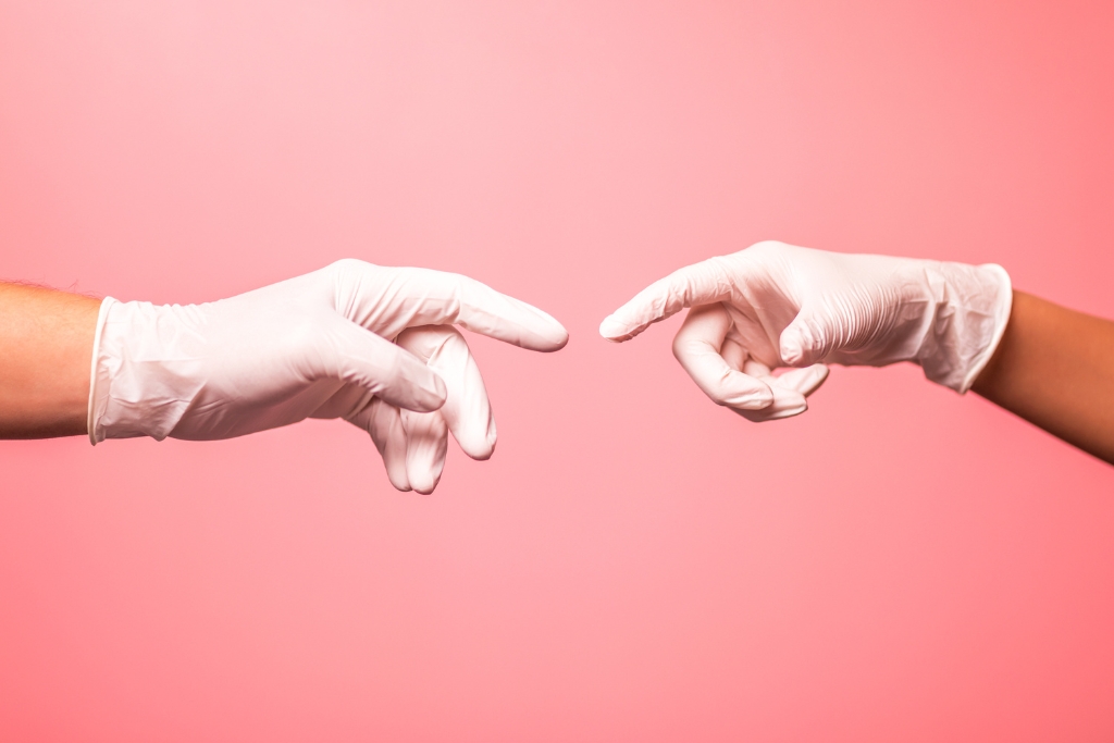 dos manos con guantes rosas desechables
